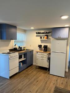 a kitchen with white appliances and wooden floors at Nature Coast Inn & Cottages in Inglis