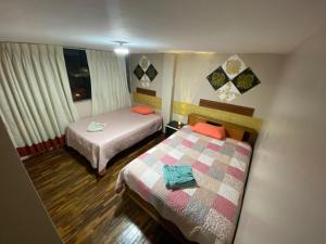 Habitación de hotel con 2 camas y ventana en Panay Guest House, en Cusco