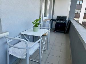 balcón pequeño con mesa, sillas y fogones en Luxembourg city appartement 105m2 with balcony, en Luxemburgo