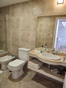 a bathroom with a toilet and a sink and a tub at Departamento en San Carlos de Bariloche, Argentina in San Carlos de Bariloche