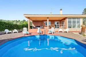 a villa with a swimming pool in front of a house at Can Montclar - Preciosa casa cerca de Cambrils in Tarragona