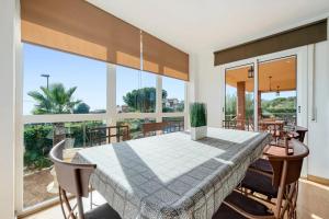 uma sala de jantar com uma mesa e janelas grandes em Can Montclar - Preciosa casa cerca de Cambrils em Tarragona