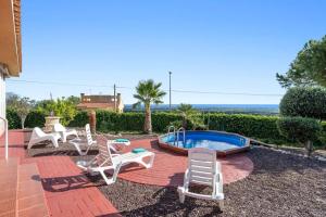 a patio with chairs and a pool and the ocean at Can Montclar - Preciosa casa cerca de Cambrils in Tarragona