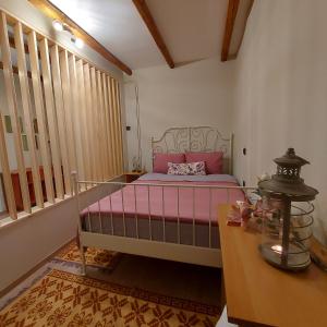 sypialnia z łóżkiem z różową pościelą i stołem w obiekcie Theasis home 
