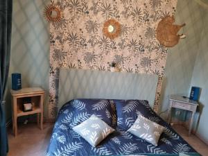 Schlafzimmer mit einem Bett mit blauen und weißen Kissen in der Unterkunft Chambre au calme proche de la nature in Auxi-le-Château