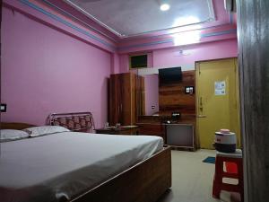 a bedroom with a bed and a yellow door at Near Sea Beach Purbasha in Digha