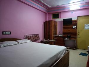 a bedroom with a bed and a tv in a room at Near Sea Beach Purbasha in Digha