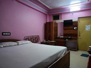 a bedroom with a bed and a tv in a room at Near Sea Beach Purbasha in Digha