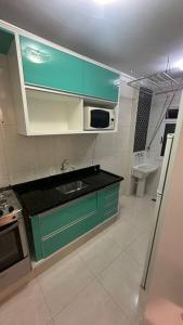 una cocina con armarios verdes y fregadero en Apto próx arm Panunzzio com piscina, en Sorocaba