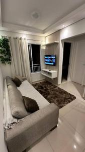 sala de estar con sofá y TV en Apto próx arm Panunzzio com piscina, en Sorocaba
