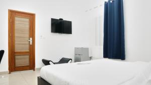 a bedroom with a bed and a tv on a wall at SOFT HOTEL in Douala