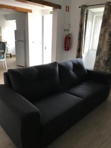 a black leather couch in a living room at Casa do Balcão in Meda