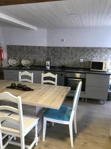 uma cozinha com uma mesa de madeira e cadeiras em Casa do Balcão em Mêda