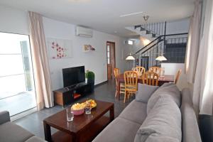 een woonkamer met een bank en een tafel bij Villa Can Bella, 350m zum Strand in Cala Galdana