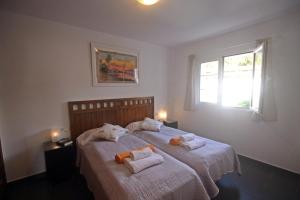 Villa Can Bella, 350m zum Strand في كالا غلدانا: غرفة نوم بسريرين عليها مناشف