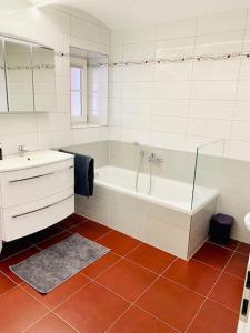 a white bathroom with a tub and a sink at Terrassenwohnung mit Donaublick in Obernzell