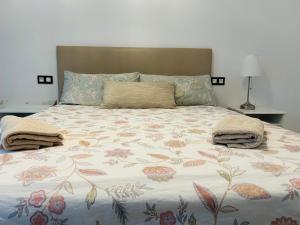 1 cama grande con colcha de flores y 2 almohadas en Victoria Beach Premium, en Málaga