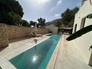 una piscina di fronte a un edificio di Preciosa Villa en Siesta a Santa Eularia des Riu