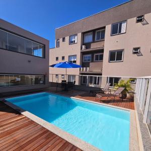 a swimming pool on a deck next to a building at Apartamento de Luxo com Piscina em Bombinhas in Bombinhas