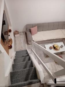 a living room with a couch and a staircase at Maksumic Apartman in Mostar