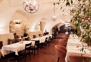 a dining room with tables and chairs and chandeliers at Hotel Livadić in Samobor