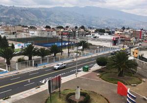 a city with a street with cars on a highway at Hotel Suites La Fontana in Ambato