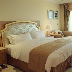 a bedroom with a large bed and a chair at Duplex by Aqua Maadi Degla Group 5 stars in Cairo