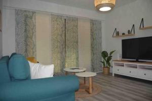 a living room with a blue couch and a flat screen tv at Apartamento en Los Acantilados de los Gigantes in Acantilado de los Gigantes