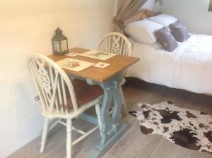 een houten tafel met 2 stoelen en een bed bij Wharfe Pod in Kettlewell +4 foto's