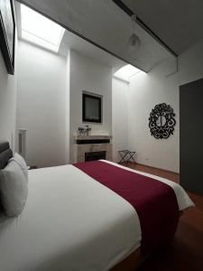 a bedroom with a large white bed and a window at Hotel Alhaja in Puebla