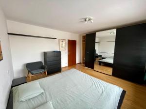 Un dormitorio con una cama y una silla dentro. en Luxembourg city appartement 105m2 with balcony, en Luxemburgo
