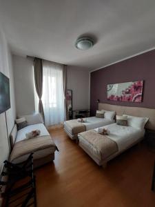 a hotel room with two beds and a window at B&B Gaudium Colosseo in Rome