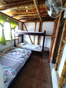 a bedroom with two beds and a fan in a room at Hotel santa marta Melgar in Melgar
