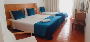 a hotel room with two beds with blue sheets at Hotel Santa Cruz in Santa Cruz