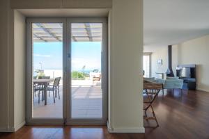 a living room with a sliding glass door leading to a patio at Casa dos Ciprestes in Ericeira