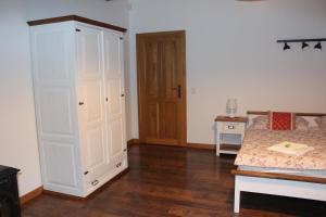 a bedroom with a bed and a large white cabinet at Penzion Za plotem 