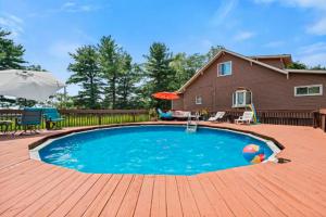 a swimming pool on a wooden deck with a house at Cheerful 4BR Chalet with Seasonal Pool, Hot Tub in New Kensington