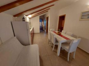 een keuken en eetkamer met een witte tafel en stoelen bij Apartment Ljubac 3 in Ljubač