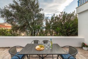 a table with a bowl of fruit and a bottle of wine at Apartment in Cala Gonone - Nuoro (Provinz) 48226 in Cala Gonone +26 photos