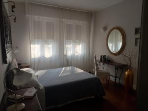 a bedroom with a bed and a table and a mirror at Maison B - Locazione turistica in Brugherio