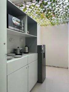 a kitchen with white cabinets and a black refrigerator at Casa Apartament Paseo Del Mar in Chimbote