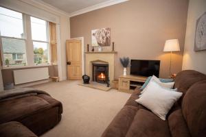 a living room with a couch and a fireplace at Purves Cottage in Allanton