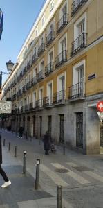 una persona caminando delante de un gran edificio en HOSTAL DANIEL, en Madrid