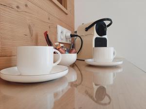 deux tasses à café assises sur un comptoir dans une cuisine dans l'établissement Chambre privée Au pied des Vosges, à Remiremont
