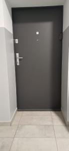 チェンストホヴァにあるKawalerka Centrum parking prywatnyのタイルフロアの部屋の黒いドア