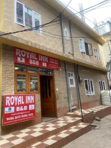 西姆拉的住宿－BNB ROYAL INN SHIMLA，前面有皇家旅馆标志的建筑