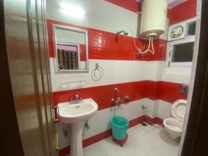 a red and white bathroom with a sink and a toilet at BNB ROYAL INN SHIMLA in Shimla
