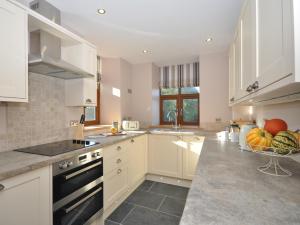 a kitchen with white cabinets and a bowl of fruit on the counter at 2 bed in Abergavenny 65965 in Pandy