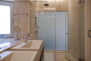a bathroom with two sinks and a shower with a glass door at Casa dos Ciprestes in Ericeira