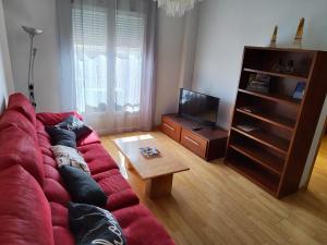 Sala de estar con sofá rojo y mesa de centro en San Miguel, en Membrilla